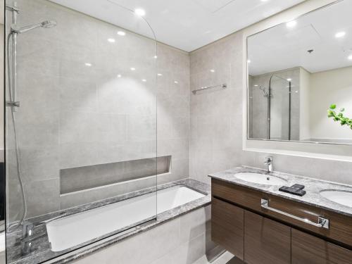 a bathroom with a tub and a sink and a shower at Exquisite 2BDR Retreat In Forte-33 in Dubai