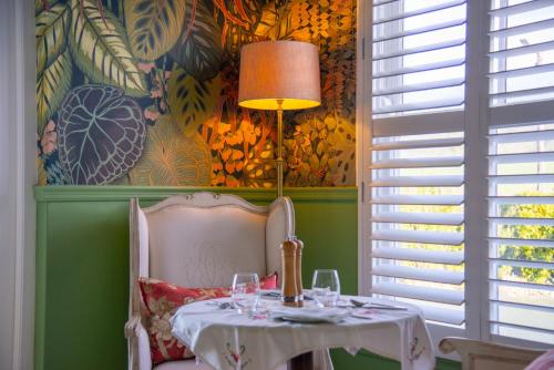 a table with a lamp and a table with wine glasses at Marrian George Hotel in Koringberg