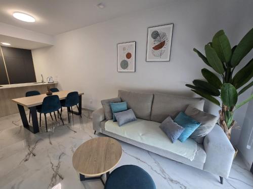 a living room with a couch and a table at Playa Flamenca modern groundfloor apartment with pool access in Orihuela Costa