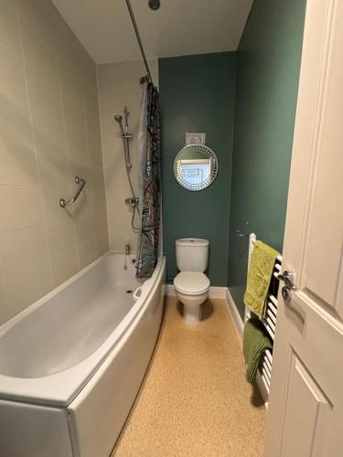 a bathroom with a white tub and a toilet at Seabreeze Apartment in Eastbourne