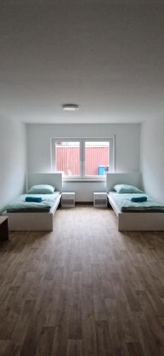a large room with two beds and two windows at Privatpension Dreger in Alzey