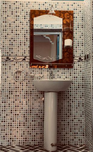 a bathroom with a sink and a mirror on a wall at Riad lina in Tafraout