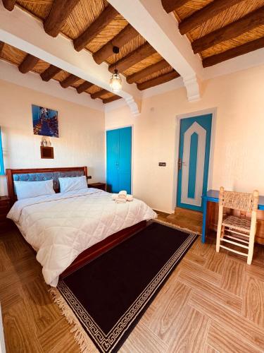 a bedroom with a large bed and a wooden ceiling at Riad lina in Tafraout