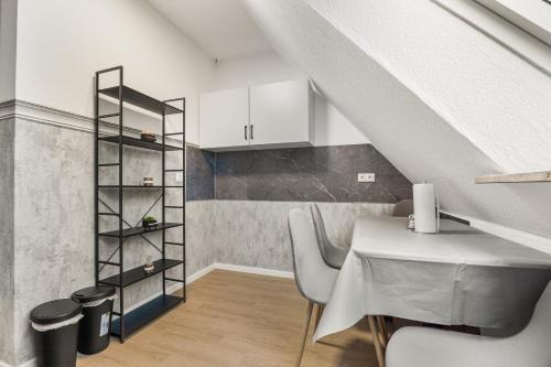 a dining room with a table and a staircase at Heide Ferienwohnung West Nr-4 in Schneverdingen