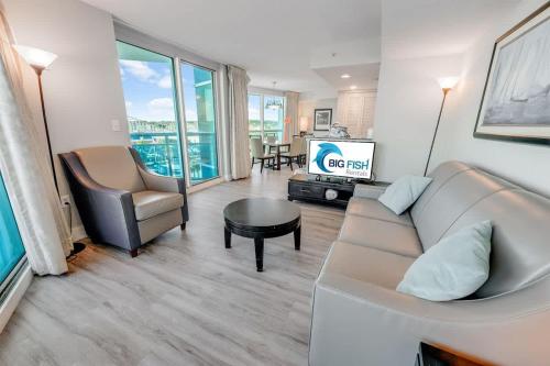 a living room with a couch and a tv at New Corner Suite 2BR, Direct Ocean and City Views in Myrtle Beach