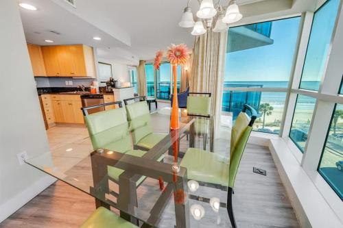 a dining room with a glass table and green chairs at New Corner Suite 2BR, Direct Ocean and City Views in Myrtle Beach