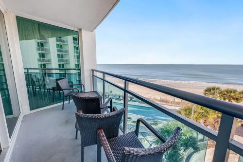 a balcony with chairs and a view of the ocean at New Corner Suite 2BR, Direct Ocean and City Views in Myrtle Beach