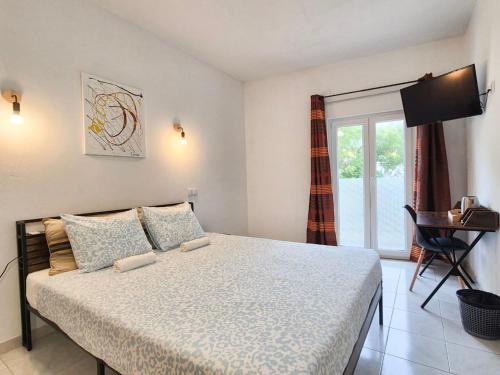 a bedroom with a large bed and a window at The Central Guesthouse in Faro