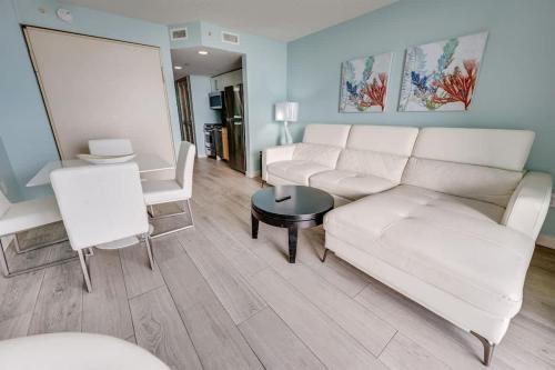 a living room with a white couch and a table at Low Floor,Modern Building, Pools Direct Oceanfront in Myrtle Beach