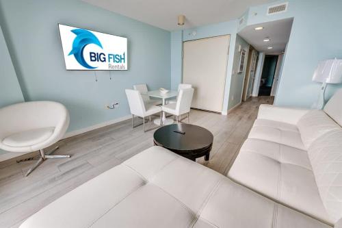 a living room with a white couch and a table at Low Floor,Modern Building, Pools Direct Oceanfront in Myrtle Beach