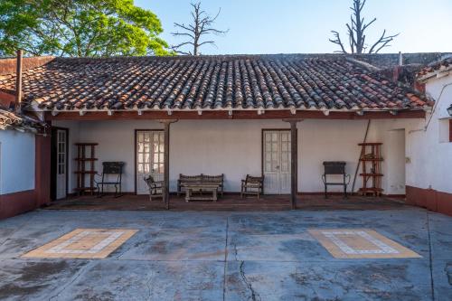 an outside view of a house with chairs and a roof at La estancia Yapeyú in Yapeyú