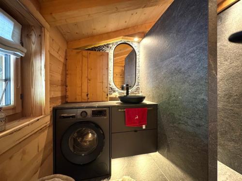a washing machine in a bathroom with a sink at Chalet Flond in Obersaxen