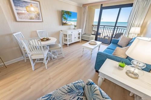 a living room with a blue couch and a table at Direct Ocean Front, The Pavilion, Pools, Boardwalk in Myrtle Beach