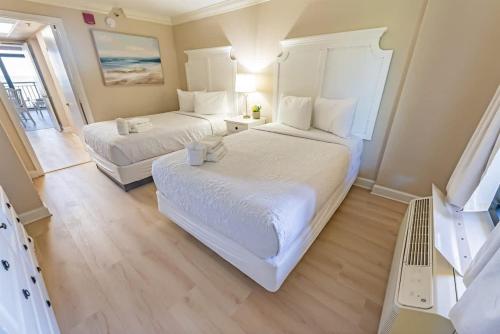 a bedroom with two beds and a table and a window at Direct Ocean Front, The Pavilion, Pools, Boardwalk in Myrtle Beach