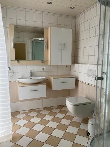 a bathroom with a sink toilet and a mirror at Cliner Blick in Wittmund