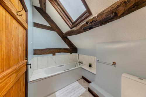 a bathroom with a bath tub and a wooden door at 3 Bed in Denbigh oc-waf147 in Gwaynynog