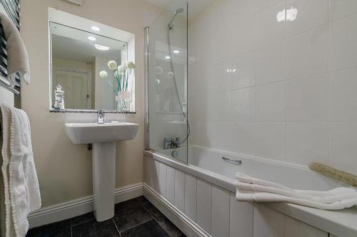 a bathroom with a sink and a bath tub and a mirror at 2 Bed in St. Levan oc-p00788 in Saint Levan