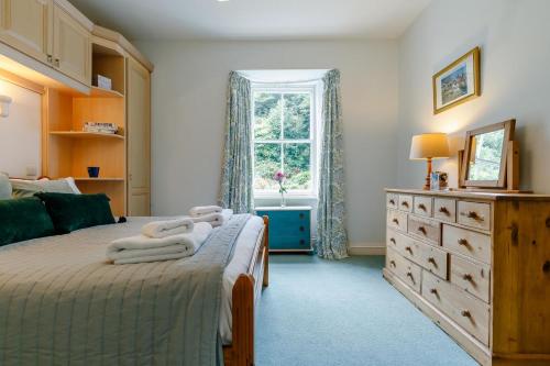 a bedroom with a bed with a dresser and a window at 2 Bed in St. Levan oc-p00788 in Saint Levan