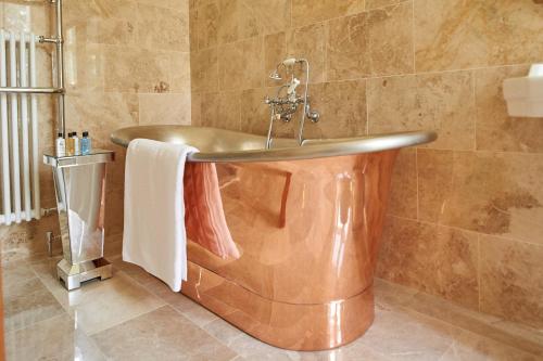 a copper tub in a bathroom with a sink at Palé Hall in Bala