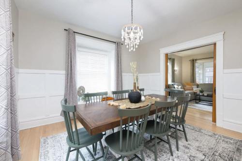 a dining room with a wooden table and green chairs at Walk to Highland Square, Sleeps 8 in Akron