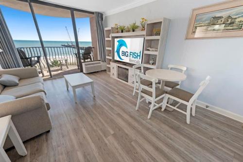 a living room with a couch and a table at 1BR Direct Oceanfront Views at Palms - Nice Pools! in Myrtle Beach