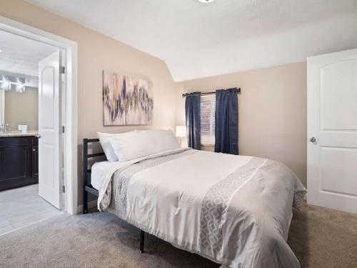 a bedroom with a large bed and a bathroom at Large Remodeled 4 Bedroom Only 7 Minutes to Downtown in Cleveland
