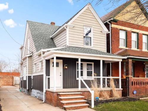 a white house with a white door and stairs at Large Remodeled 4 Bedroom Only 7 Minutes to Downtown in Cleveland