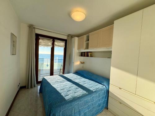 a bedroom with a blue bed and a window at Villa Luciana in Grado