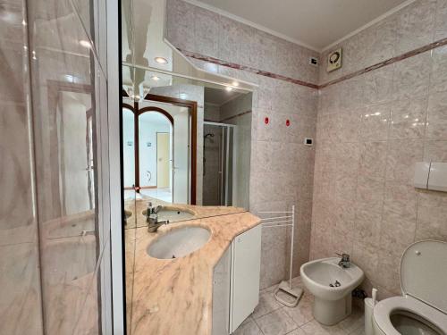 a bathroom with a sink and a toilet and a mirror at Villa Luciana in Grado