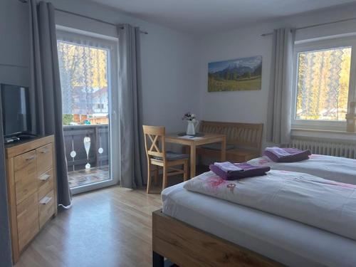 a bedroom with a bed and a table and a desk at Gästehaus Lehnerer Grainau in Grainau