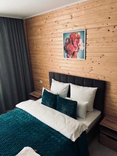 a bedroom with a bed with a wooden wall at MiS Family house з чаном та сауною in Kosiv