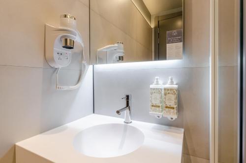 ein Badezimmer mit Waschbecken und Spiegel in der Unterkunft LX Arch Hotel in Lissabon
