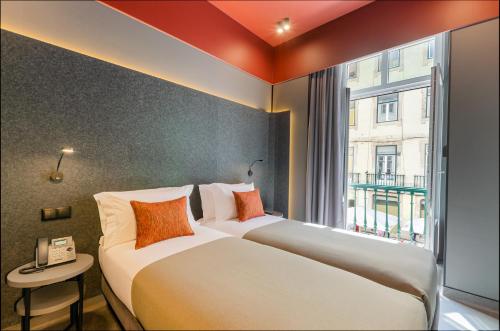 zwei Betten in einem Hotelzimmer mit Fenster in der Unterkunft LX Arch Hotel in Lissabon
