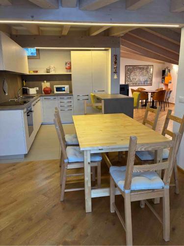 a kitchen and dining room with a wooden table and chairs at Respiro di lago in Molveno