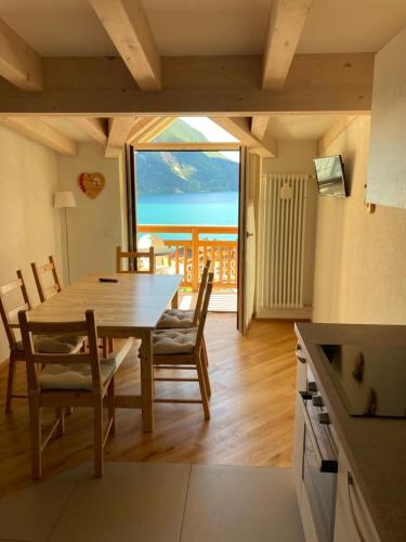 a dining room with a table and a view of the ocean at Respiro di lago in Molveno