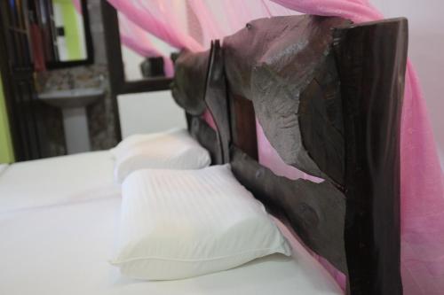 a close up of a bed with a black bag on it at Villa Eden Paradise in Ella