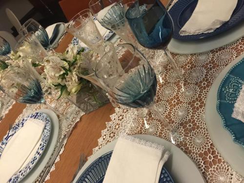 a table with blue and white plates and wine glasses at Mara Turismo Hotel in Catalão