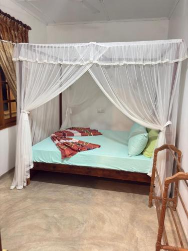 a bed with a canopy in a room at Fairview Villa in Hikkaduwa