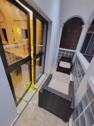 un balcone con una porta a vetri e una sedia di Résidence strawberry a Brazzaville