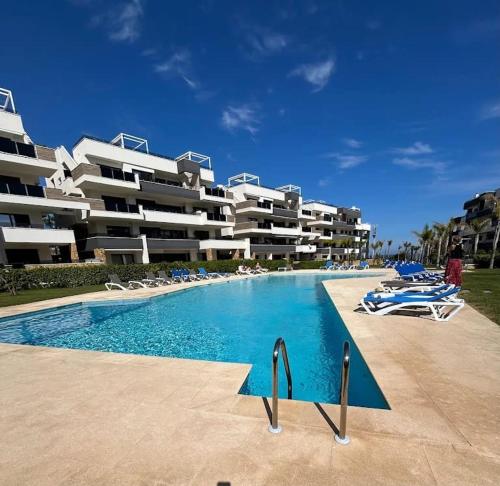 a large swimming pool in front of a hotel at Playa Flamenca modern groundfloor apartment with pool access in Orihuela Costa