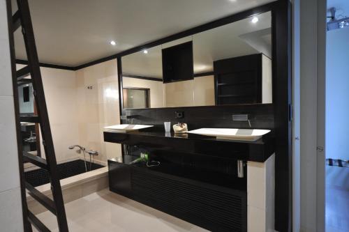 a bathroom with two sinks and a mirror at Gatto Bianco House in Bari