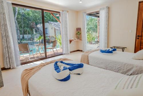 a bedroom with two beds and a large window at Villas AHAL, in Chemuyil