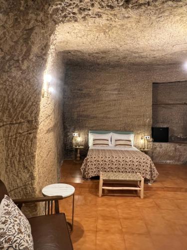a bedroom with a bed in a stone wall at AIRE Vejer - recién reformado 2026 in Vejer de la Frontera