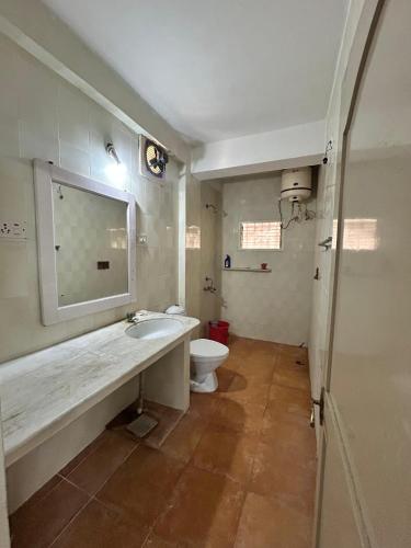 a bathroom with a sink and a toilet at Chetanya Homestay in Puttaparthi