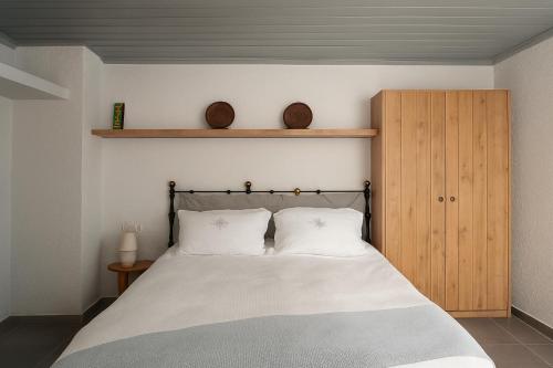 a bedroom with a bed and a wooden cabinet at Keresbino Hydra Port House in Hydra