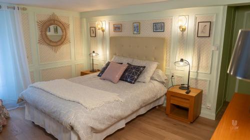 a bedroom with a bed with two lamps and a mirror at Gite le Mont Blanc in Le Mesnil-sur-Oger