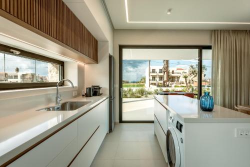 a kitchen with a sink and a washing machine at Deux Olives Luxury Villa in Maleme