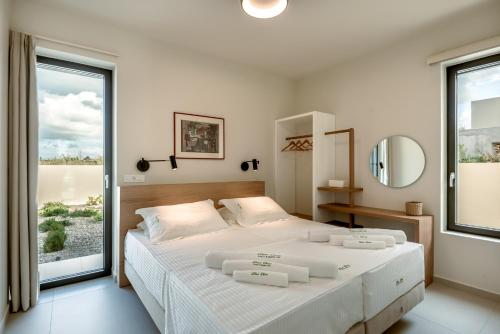 a bedroom with a large bed with two white towels on it at Deux Olives Luxury Villa in Maleme