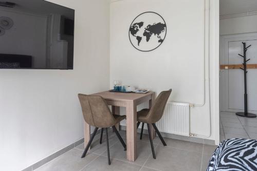 a dining room table with two chairs and a world sign on the wall at Zaras Studio Hermes in Zandvoort