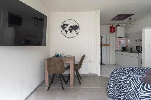 a room with a table and a bed and a kitchen at Zaras Studio Hermes in Zandvoort